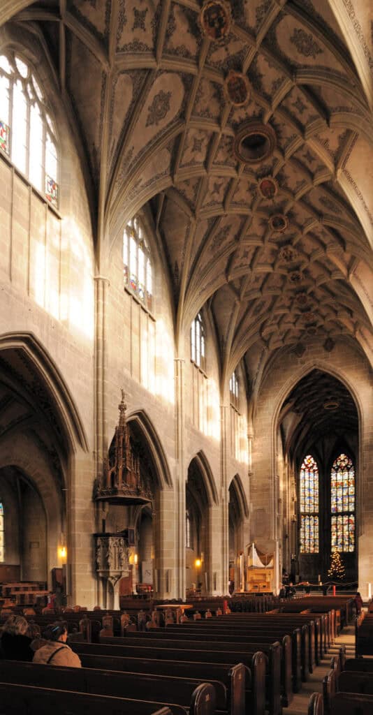 Interior of Bern Minster, showcasing Gothic architecture and ornate details.