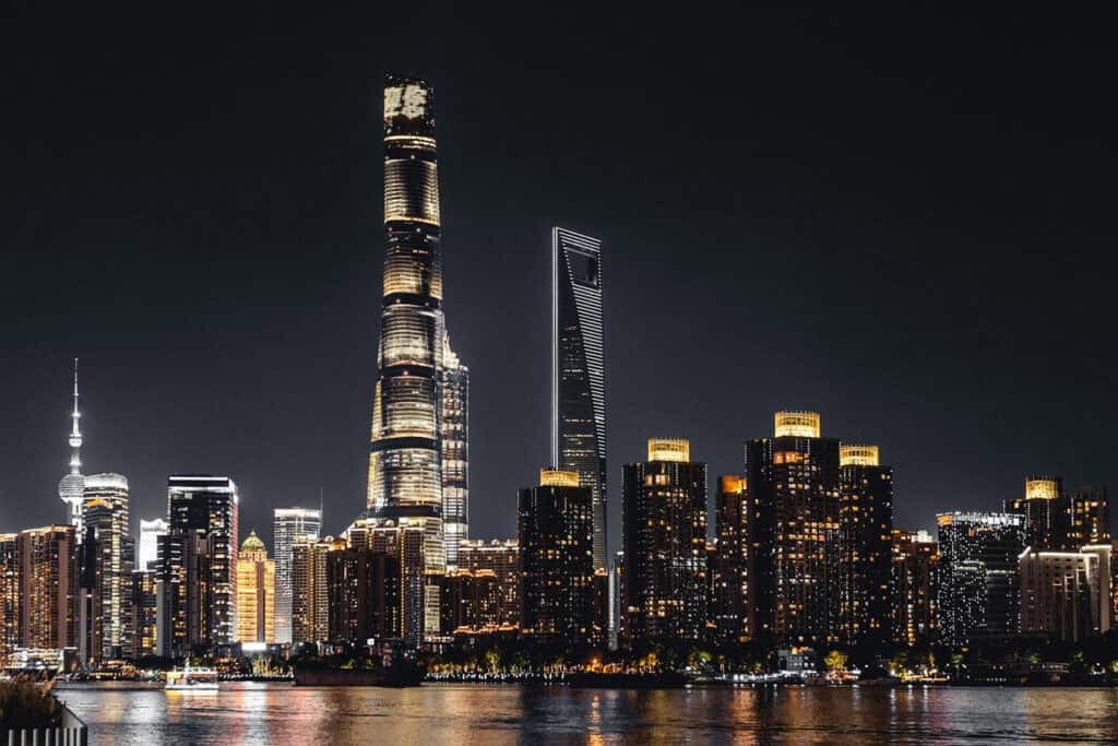 Shanghai Tower with city buildings illuminated at night