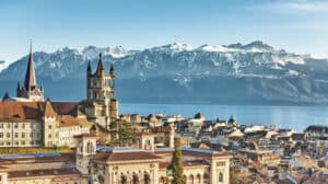 Lausanne cityscape with the cathedral, Lake Geneva, and snowy peaks.