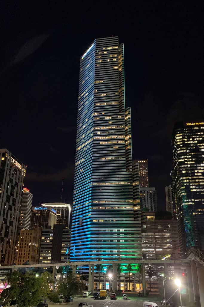 The Miami Tower illuminated at night in vibrant colors