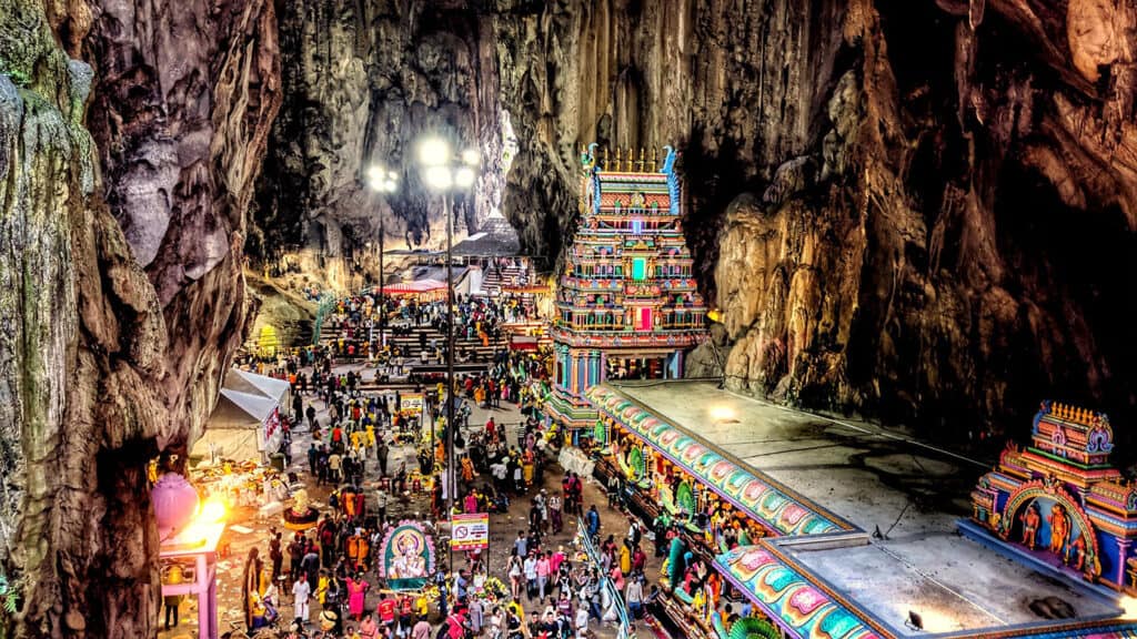 Inside the Batu Caves Temple with vibrant statues and altars.